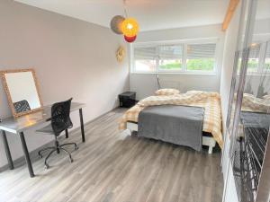 セレスタにあるA la villa du voyageur - proche Europa Park, Strasbourg et Colmarのベッドと机とテーブルのある寝室