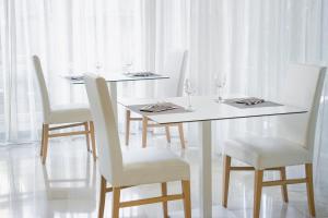 a white table with white chairs and wine glasses at Ambra Hotel Cattolica in Cattolica
