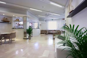 a large room with chairs and tables and plants at Ambra Hotel Cattolica in Cattolica