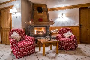 a living room with two chairs and a fireplace at Chalet Barragiste in Courchevel