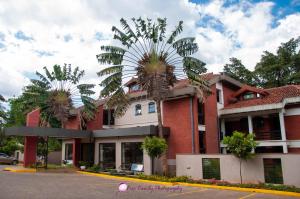 a red brick building with palm trees in front of it at Heri Heights Serviced Apartments by Trianum in Nairobi