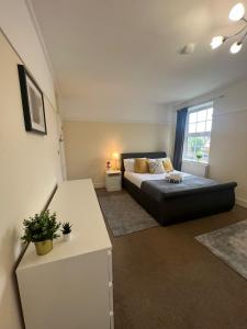 a large bedroom with a bed and a window at Stunning Wembley Stadium Flat in London