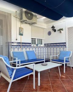 a patio with blue and white chairs and a table at Apartamento Turístico Casa Bari in Olivenza