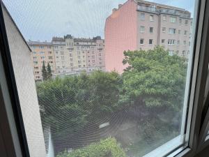 a window with a view of a building and trees at Cool Schönbrunn Apt 2BR in Vienna