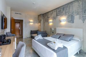 ein Schlafzimmer mit einem großen Bett, auf dem Handtücher liegen in der Unterkunft Hotel Madeira Centro in Benidorm