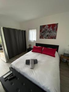 een slaapkamer met een groot bed met rode kussens bij Le chalet de la liez in Peigney