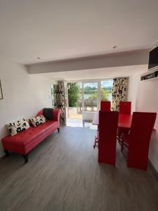 a living room with a red couch and a table at Le chalet de la liez in Peigny