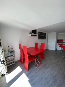een rode eettafel en rode stoelen in een kamer bij Le chalet de la liez in Peigney