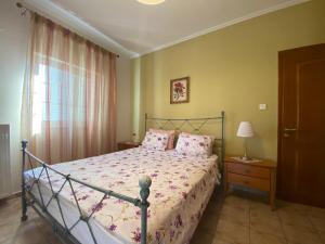 sypialnia z łóżkiem z różową pościelą i oknem w obiekcie COZY & QUIET CITY APARTMENT w mieście Tríkala