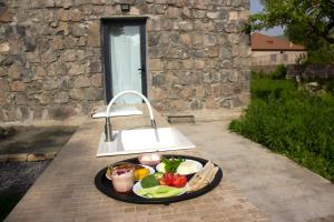 a plate of food on a table in front of a building at Zove Rural Cottage with garden views in Kʼarashamb