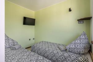 a bedroom with two beds and a flat screen tv at 18 Gdynia Centrum - Apartament Mieszkanie dla 4 os in Gdynia