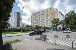 een parkeerplaats met een gebouw en auto's op straat bij 18 Gdynia Centrum - Apartament Mieszkanie dla 4 os in Gdynia