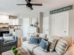 a living room with a white couch and a ceiling fan at 7 Seas Unit 4 in Tybee Island