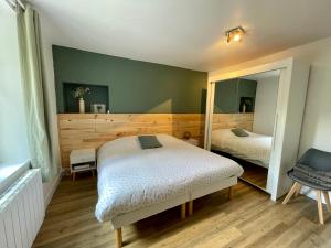 1 Schlafzimmer mit 2 Betten und einem Spiegel in der Unterkunft Le gîte du lavoir 