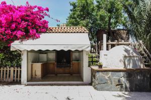 un pequeño edificio con un árbol de flores rosas en CORTIJO EL LLANO GRAND, en Almería
