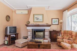 a living room with a fireplace and a tv at CORTIJO EL LLANO GRAND in Almería