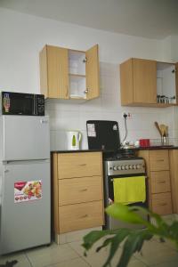 Il comprend une cuisine équipée d'un réfrigérateur blanc et d'une cuisinière. dans l'établissement Nairobi Affordable studio apartments hosted by Lilian, à Nairobi