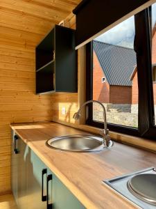 a kitchen counter with a sink and a window at Cottage Carpe Diem in Stepantsminda