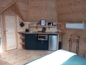 a small kitchen in a wooden cabin with a stove at Insolite: Le Kota du Lutin Many in Saint-Christophe-sur-Condé +19 photos
