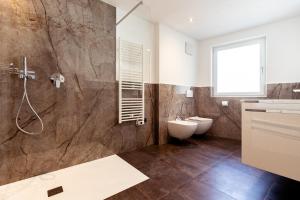 サン・マルティーノにあるRamoser Living Apartmentsのシャワー、トイレ、洗面台を備えたバスルーム +19枚の写真