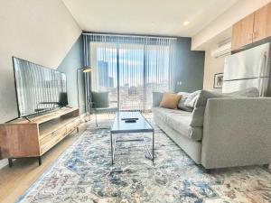 Una sala de estar con un sofá y un televisor. en Hidden Gem Apartment In Downtown, en San Diego