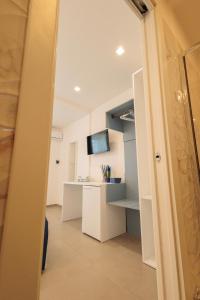 um corredor com um quarto com uma secretária e uma televisão em Orizzonte Mare Panoramic Rooms em Agropoli
