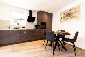 サン・マルティーノにあるRamoser Living Apartmentsのテーブルと椅子のあるキッチンとダイニングルーム
