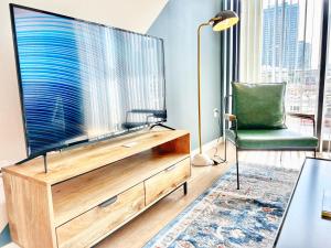 sala de estar con TV grande y silla verde en Hidden Gem Apartment In Downtown, en San Diego 10 fotos más