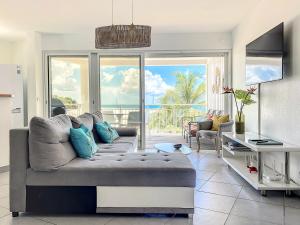 a living room with a couch and a view of the ocean at Kokonut Sea view Beach Front Pool Central Garage in Grand Case