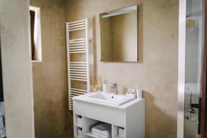 uma casa de banho com um lavatório branco e um espelho. em PENSIUNE-RESTAURANT Palace em Cărpinet