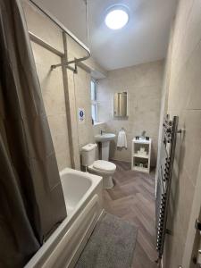 a bathroom with a tub and a toilet and a sink at Stunning Wembley Stadium Flat in London +19 photos
