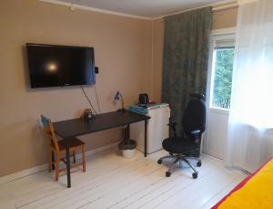 a room with a desk and a television on the wall at Cheerful 1-bedroom, 120 m from Sandbach in Bräcke