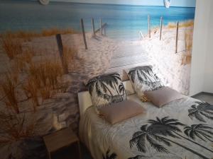 Le gîte lorette في إبينال: غرفة نوم مع لوحة جدارية للشاطئ
