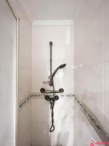 a shower in a bathroom with white tiles at Brisa Marina Mediterránea in Oropesa del Mar