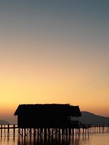 une cabane en bois dans l'eau au coucher du soleil dans l'établissement Lalosi Homestay, à Besir