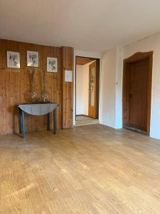 pusty pokój ze stołem i drewnianą podłogą w obiekcie Ferienwohnung MaLi w mieście Arrach