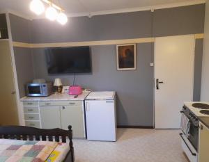 a kitchen with a white refrigerator and a microwave at Bedroom with kitchen, 120 m from Sandbach in Bräcke