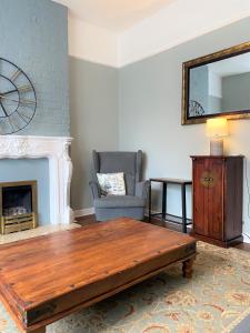 a living room with a coffee table and a chair at Lovely Victorian House near Liverpool Centre in Liverpool