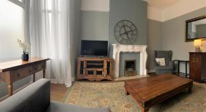 a living room with a television and a fireplace at Lovely Victorian House near Liverpool Centre in Liverpool