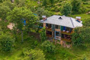 an aerial view of a house on a hill at Dharamalaya by StayVista - The Eco Home in Dharamshala