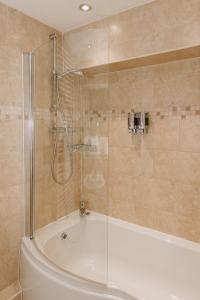 y baño con bañera y ducha acristalada. en Coach House - 4 Bedroom Self-Catering, en Preston