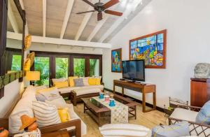 ein Wohnzimmer mit einem Sofa und einem TV in der Unterkunft Sunny vacation Villa No 67 in San Rafael del Yuma