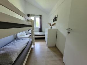 ハウスハムにあるFamilienfreundliche großzügige Ferienwohnung Schlierachwelle zwischen Schliersee und Tegernseeの二段ベッド2台、窓が備わる小さな客室です。