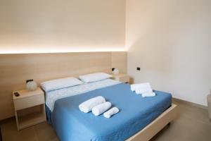a bedroom with a blue bed with towels on it at Isola Verde in Casal Velino