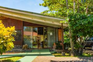 a house with a dog sitting outside of it at Hotel Bristol Aeropuerto in Alajuela City