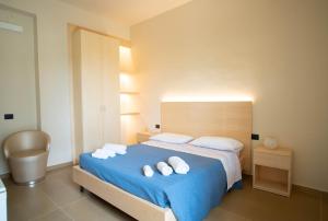 a bedroom with a blue bed with towels on it at Isola Verde in Casal Velino