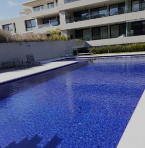 a large blue swimming pool in front of a building at Descanso garantizado! in Montevideo