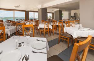 uma sala de jantar com mesas e cadeiras brancas em Mix Colombo em S'Illot