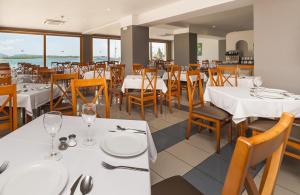 a dining room with white tables and chairs at Mix Colombo in S'Illot