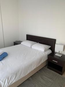 a bedroom with a bed with two nightstands and two lamps at Aphrodite Beachfront Apartment - North Cyprus in Ghaziveran
